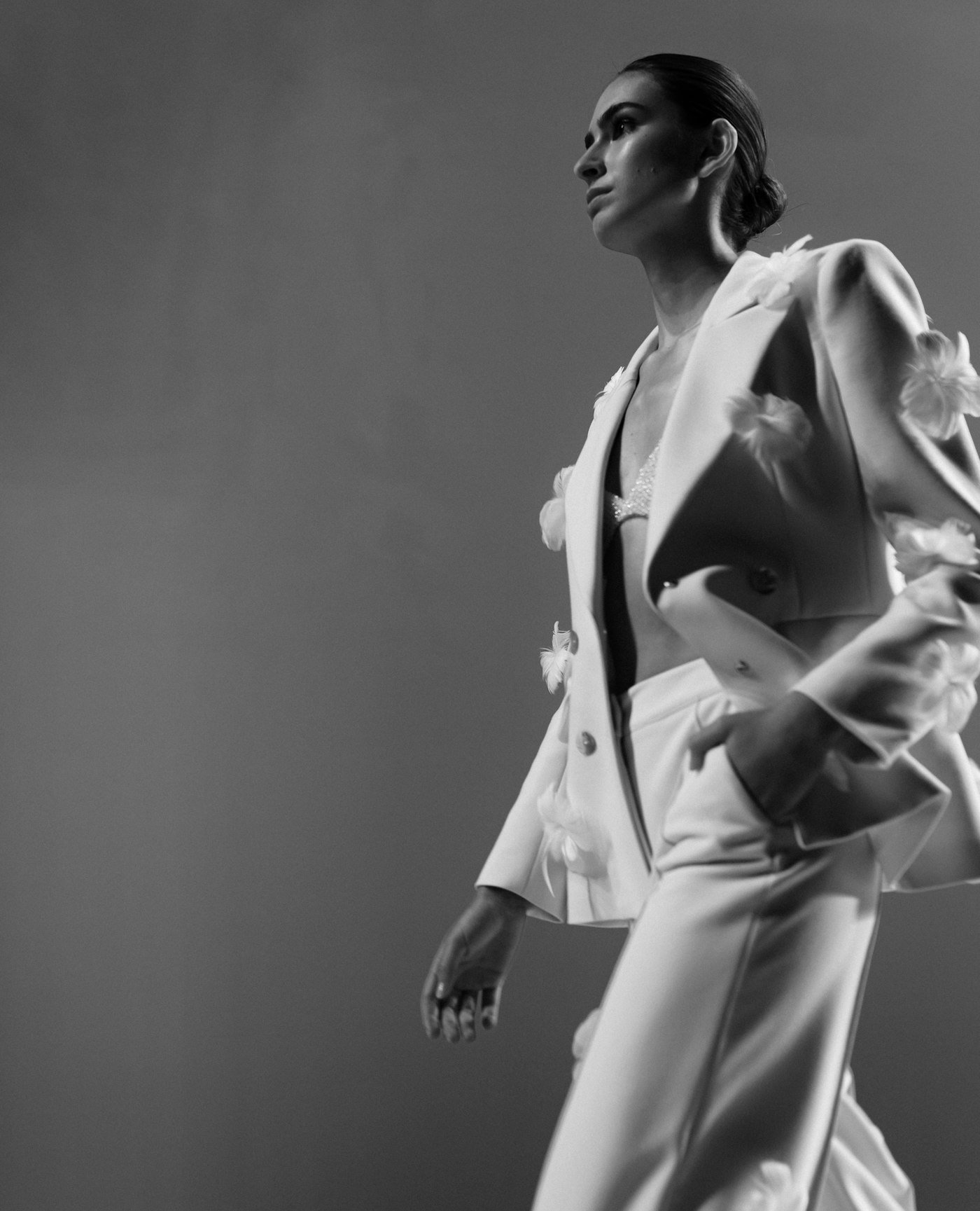 Editorial fashion portrait of a model in a tailored white suit